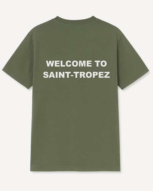 Green t-shirt with 'Welcome to Saint-Tropez' text on the back against a white background